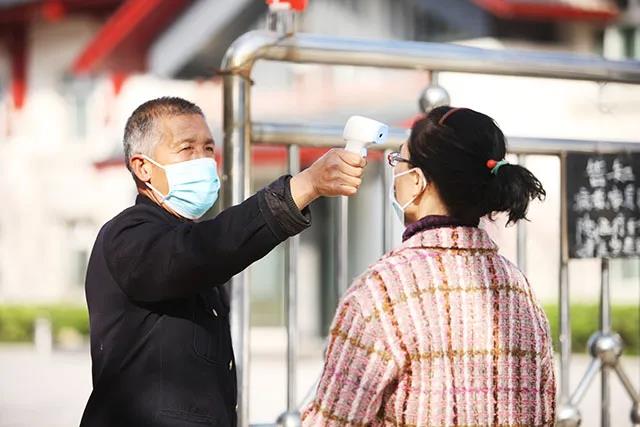 運城安國醫院（主治頸椎結核、淋巴結核復發、肺結核、骨結核等等）的一名門衛正在對前來看他的老伴進行測溫。