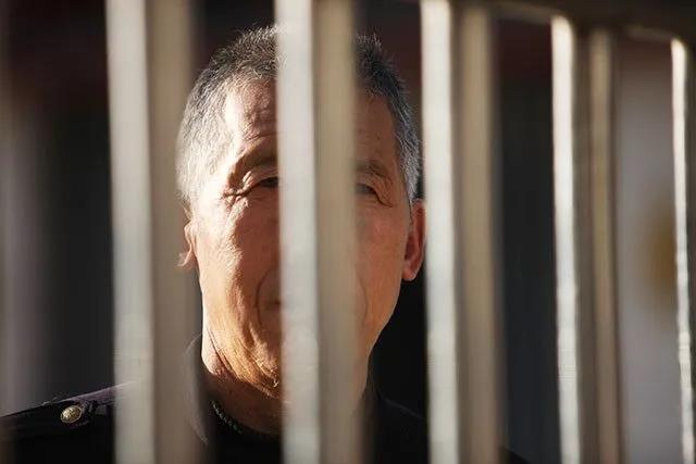 門衛正在隔著鐵門望著醫院之外親人。